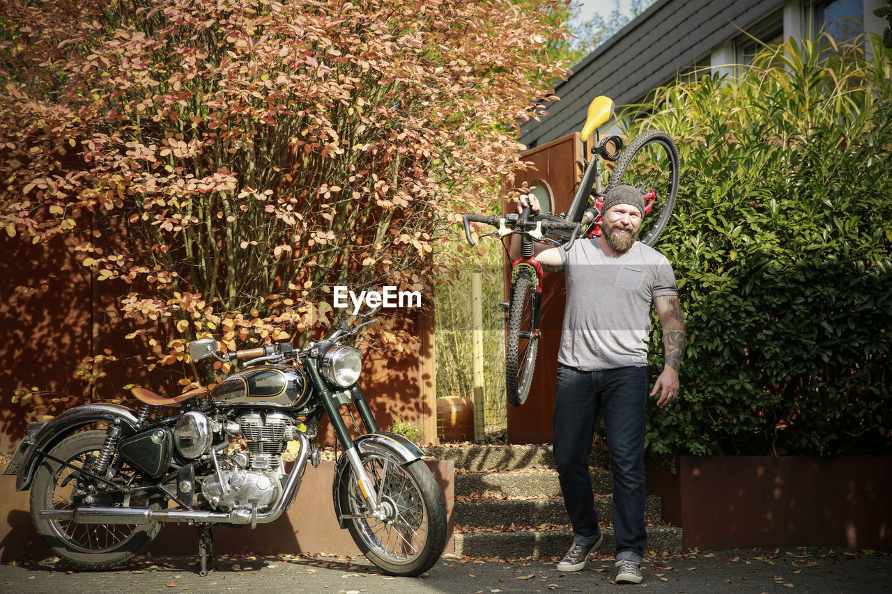 Portrait of man switching from motorbike to bicycle