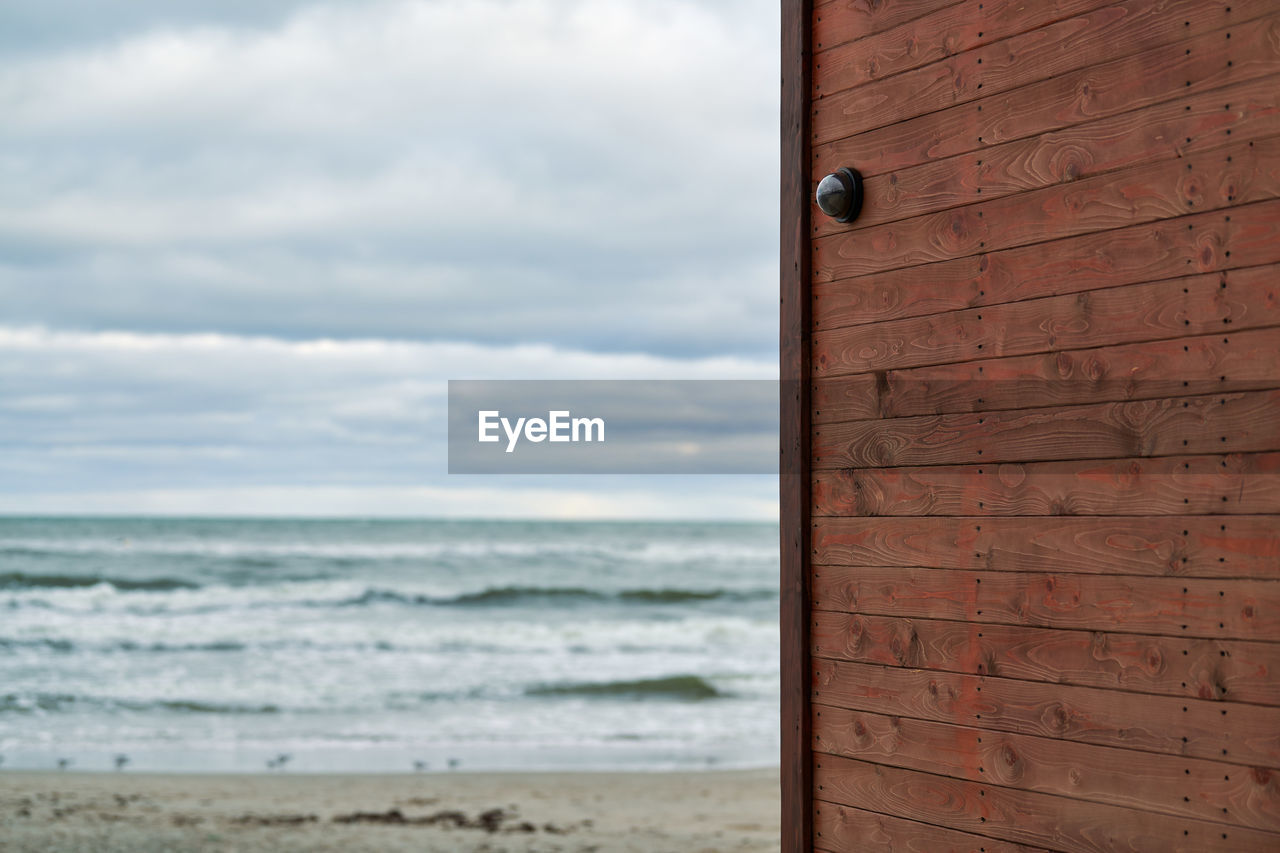 Ip cctv camera with home security system installed on wooden wall against backdrop of seascape