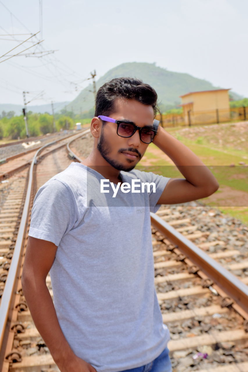 Portrait of young man wearing sunglasses standing outdoors