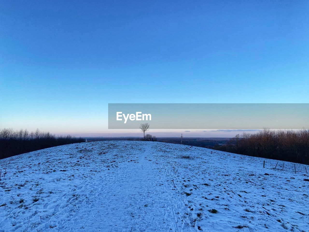 SNOW COVERED FIELD AGAINST SKY