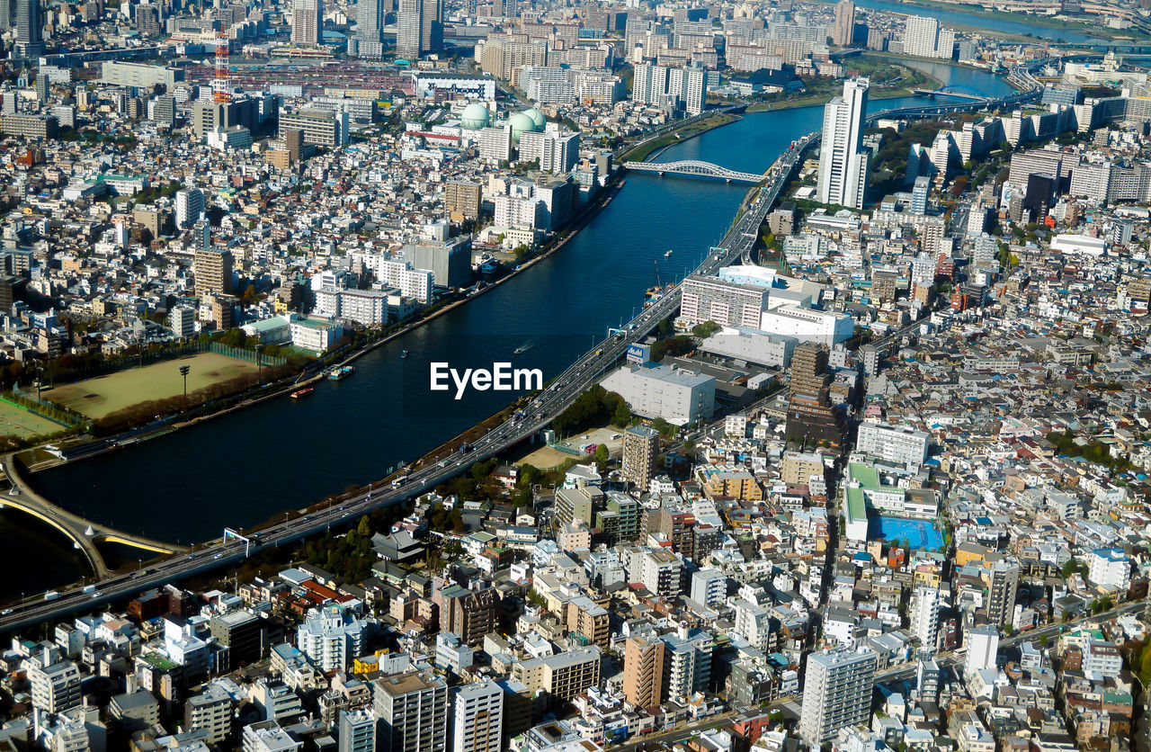 High angle view of crowd by river against buildings in city