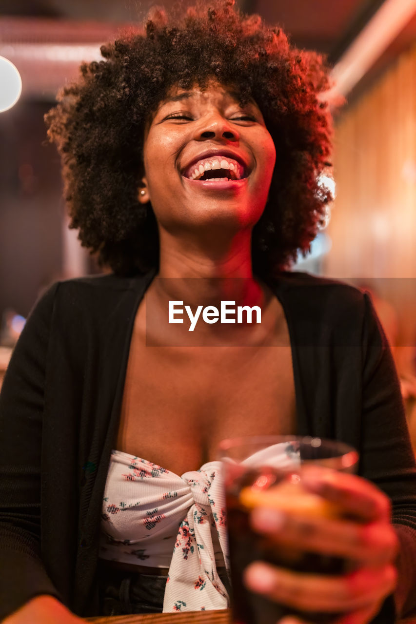 Happy afro woman at bar