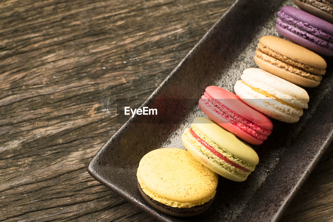 Colorful and delicious french macaron cookies varieties on a wooden table