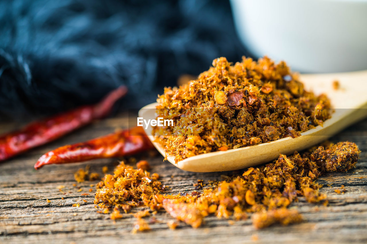 Spicy dried fishes chili paste with wooden spoon and background