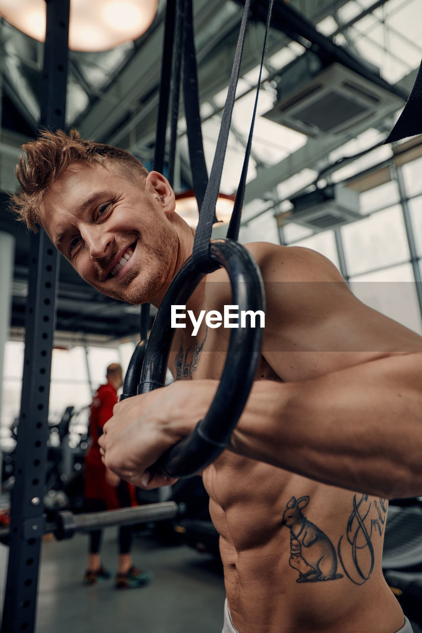 low angle view of shirtless man exercising in gym