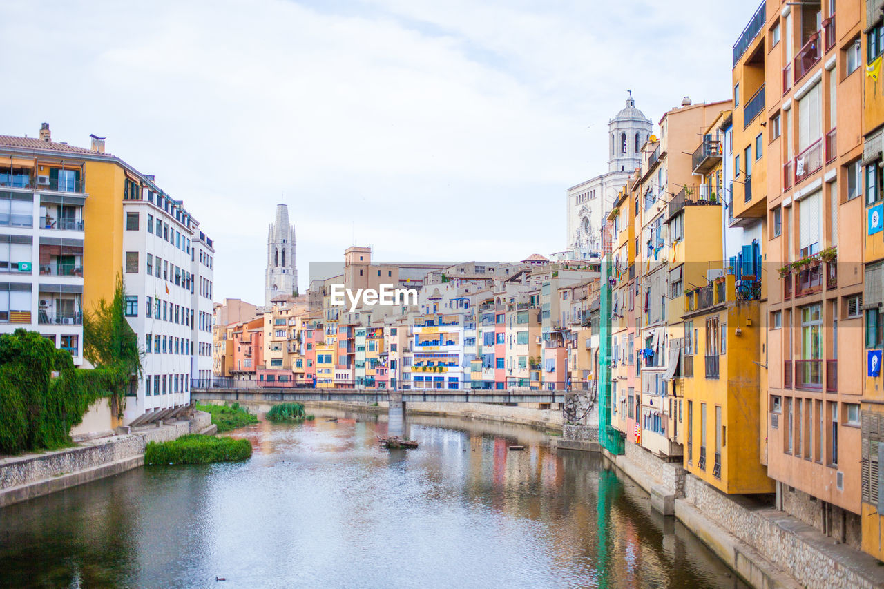 View of canal in city against sky