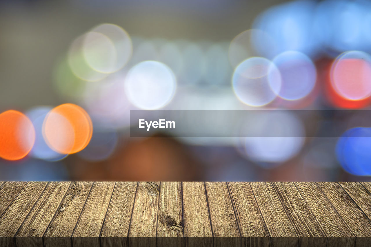 Wooden table against colorful lens flare