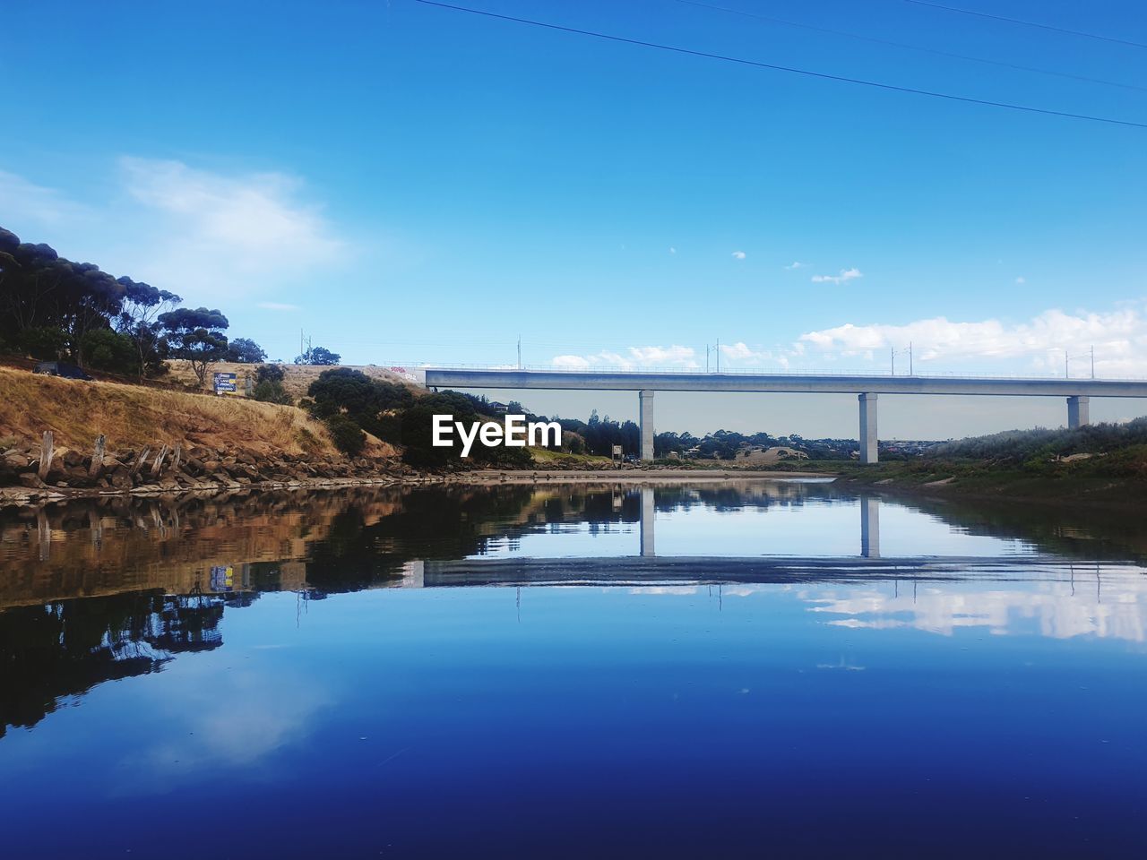 reflection, water, sky, blue, nature, scenics - nature, beauty in nature, lake, tranquility, reservoir, dusk, tranquil scene, cloud, environment, architecture, landscape, no people, body of water, morning, built structure, travel destinations, shore, outdoors, land, horizon, travel, day, idyllic, tree, standing water, bay, mountain, waterfront, plant, clear sky, non-urban scene, building