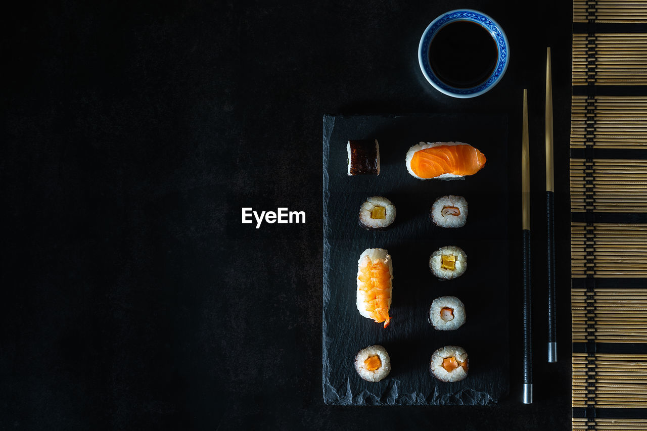 Close up healthy traditional japanese sushi set nigiri and rolls with chopsticks.