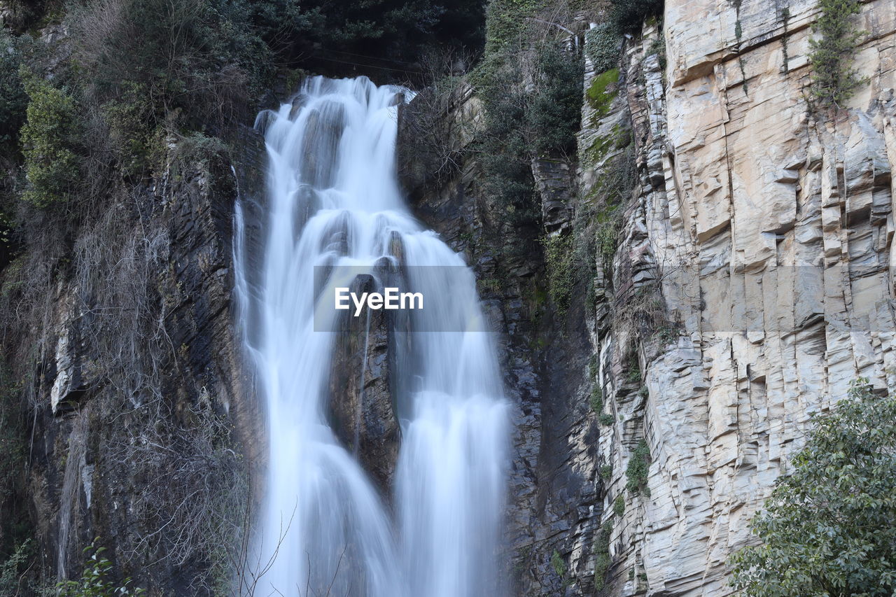 SCENIC VIEW OF WATERFALL AGAINST ROCKS