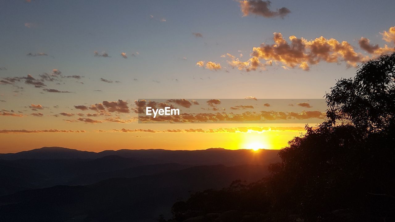 SCENIC VIEW OF SUNSET OVER MOUNTAINS