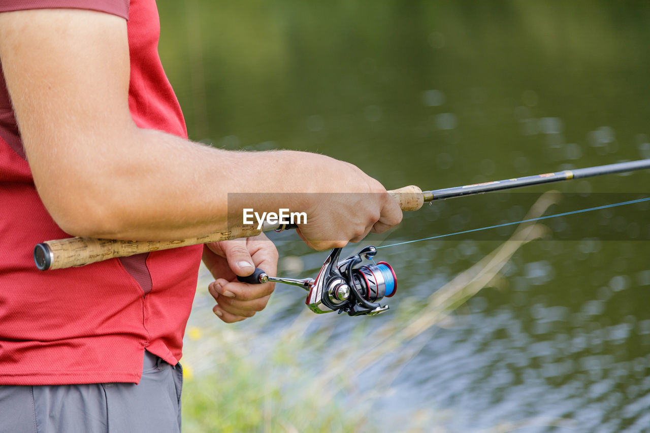 A man with a beard is fishing on the river.