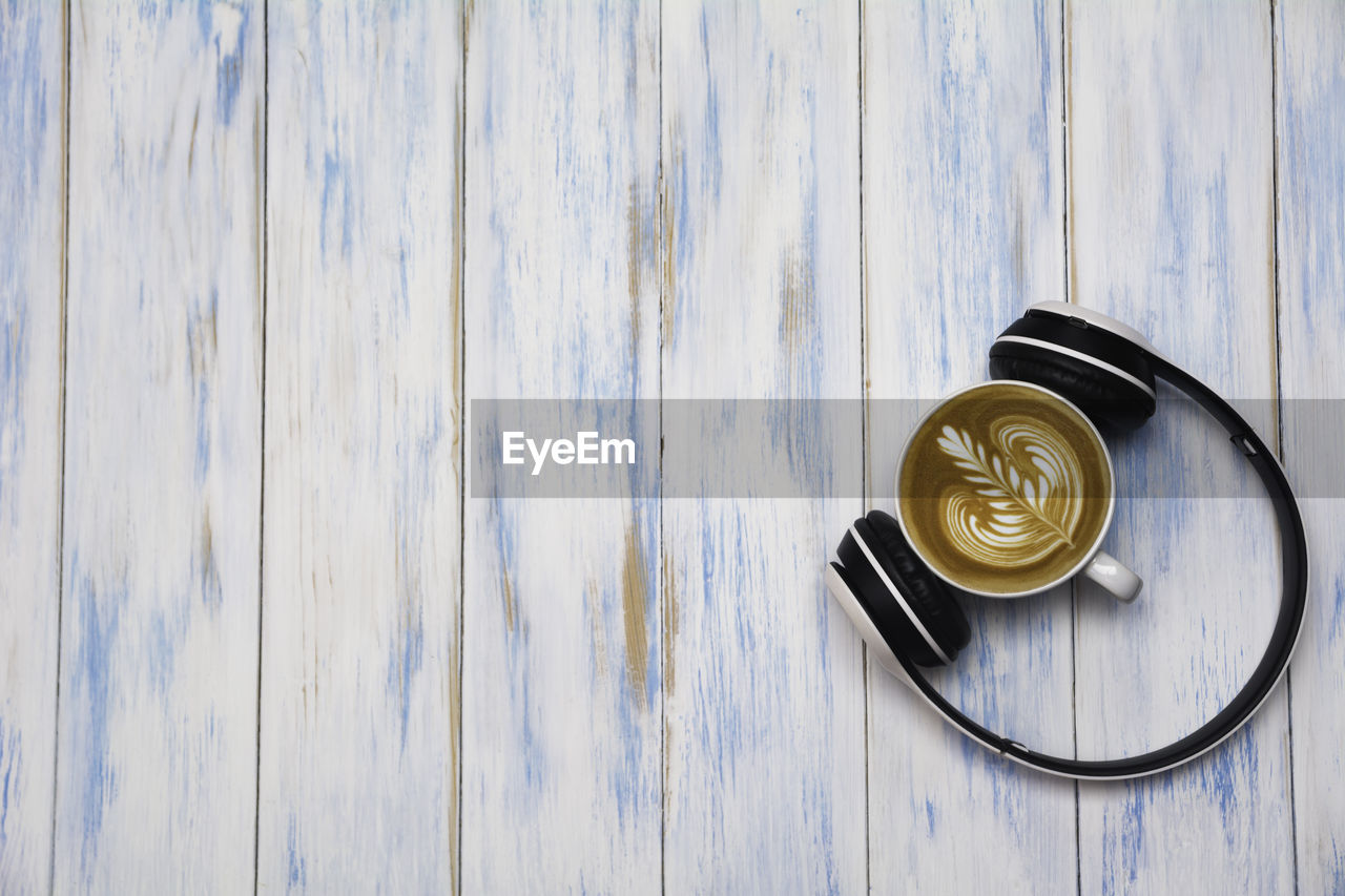 HIGH ANGLE VIEW OF COFFEE CUP ON WOODEN TABLE