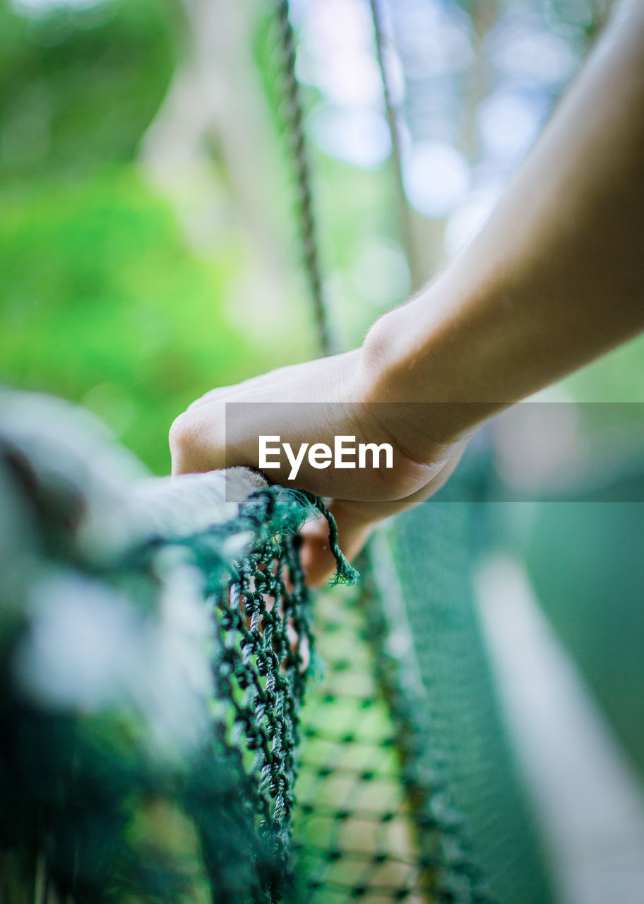 Close-up of man holding railing