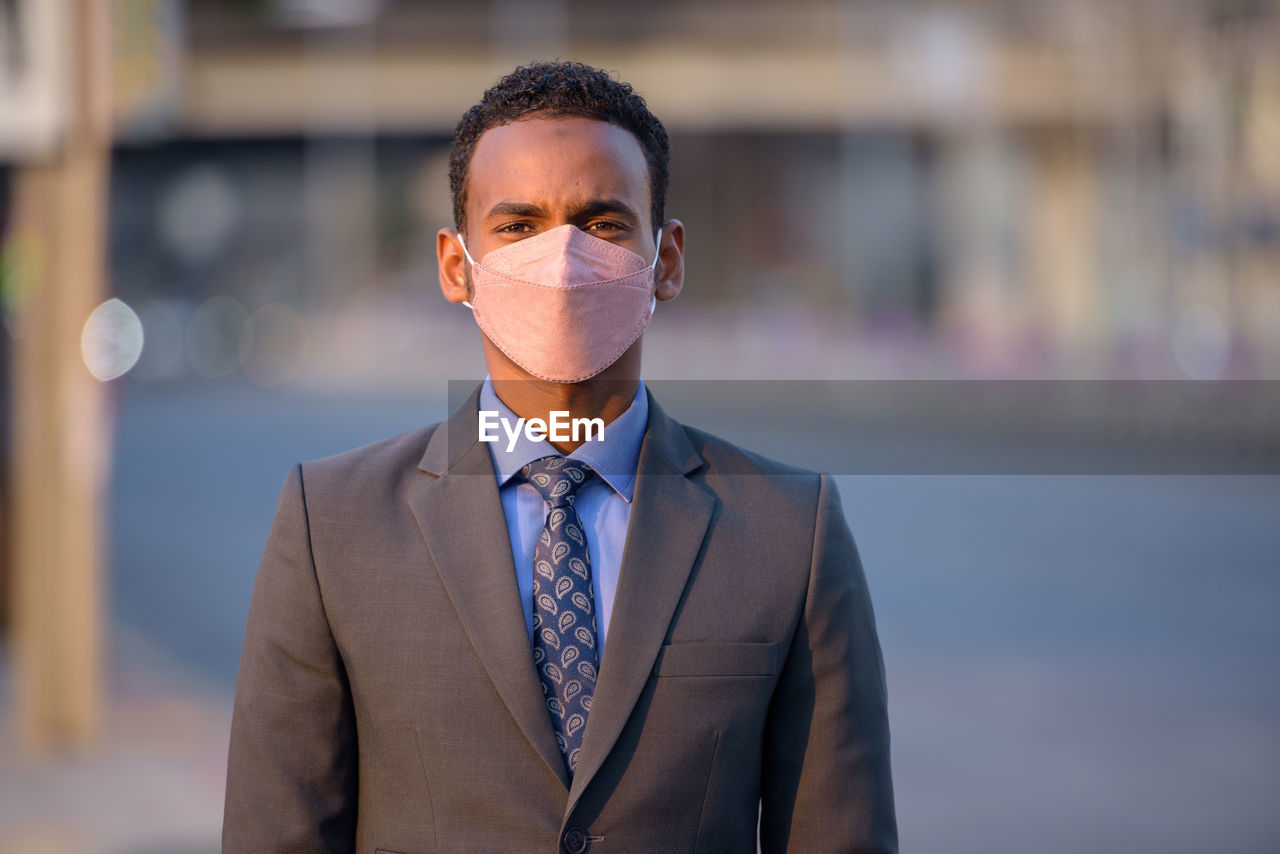 Portrait of businessman wearing mask standing outdoors