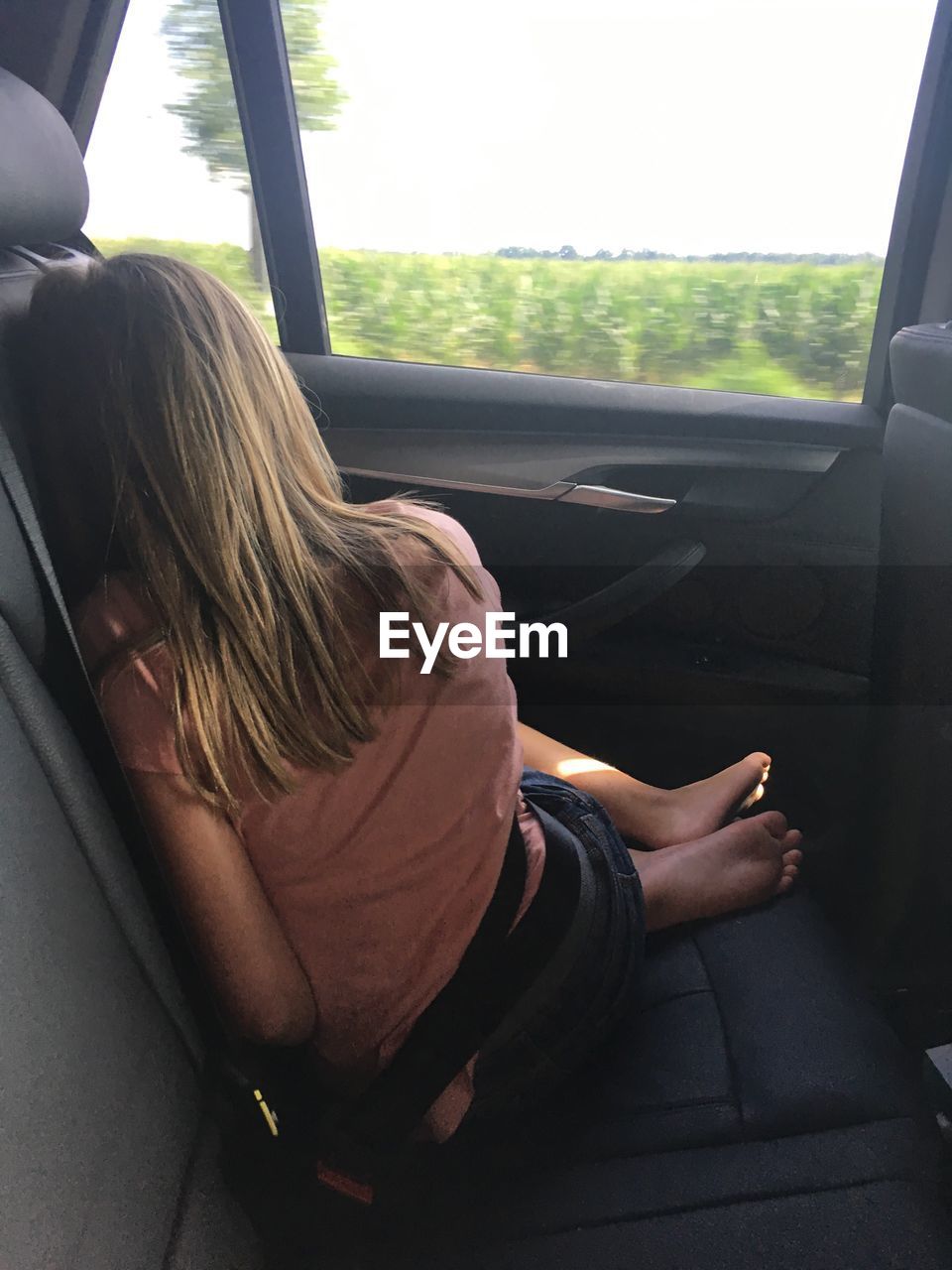 Rear view full length of teenage girl sitting in car