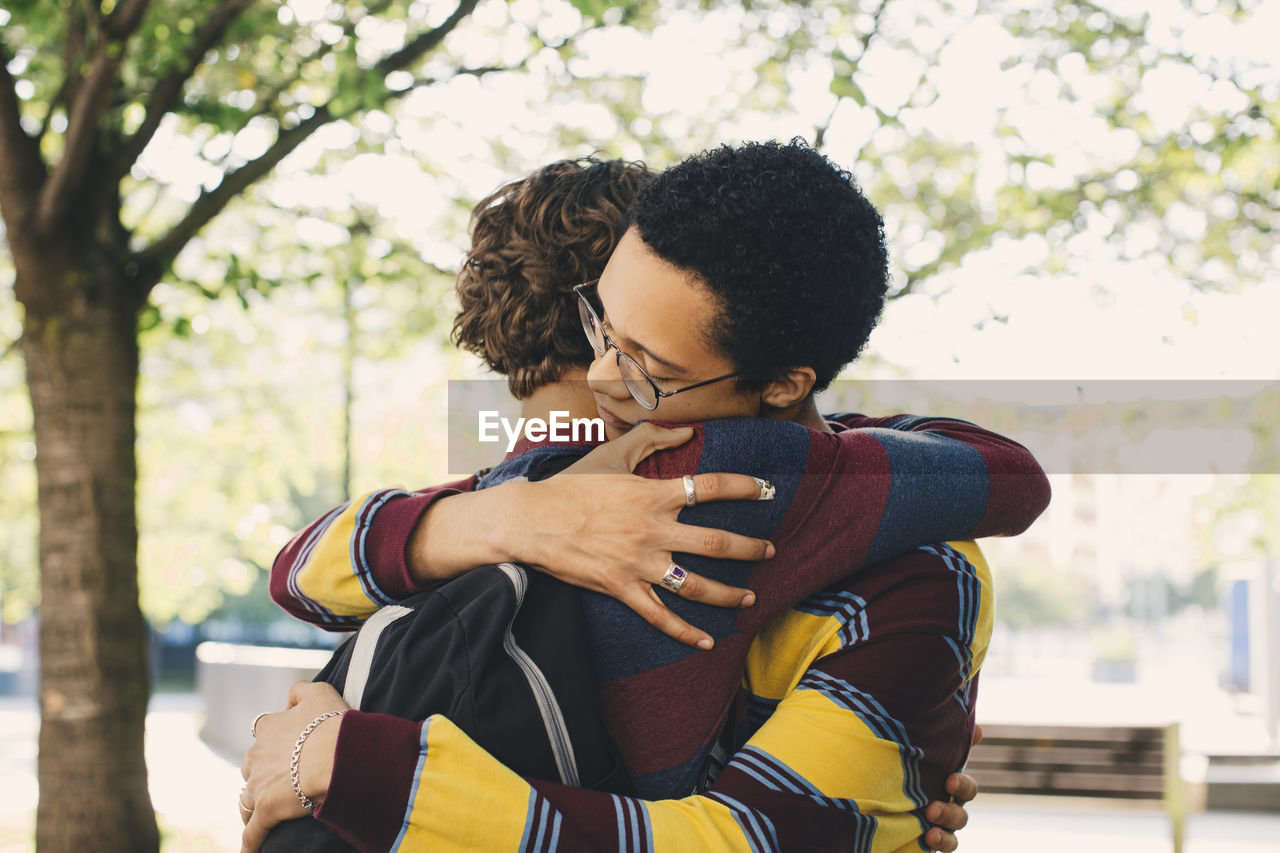 Male friends embracing each other in park