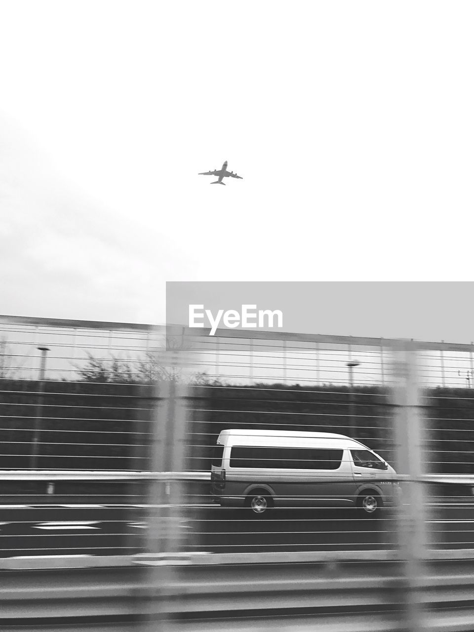 AIRPLANE FLYING OVER RUNWAY AGAINST SKY