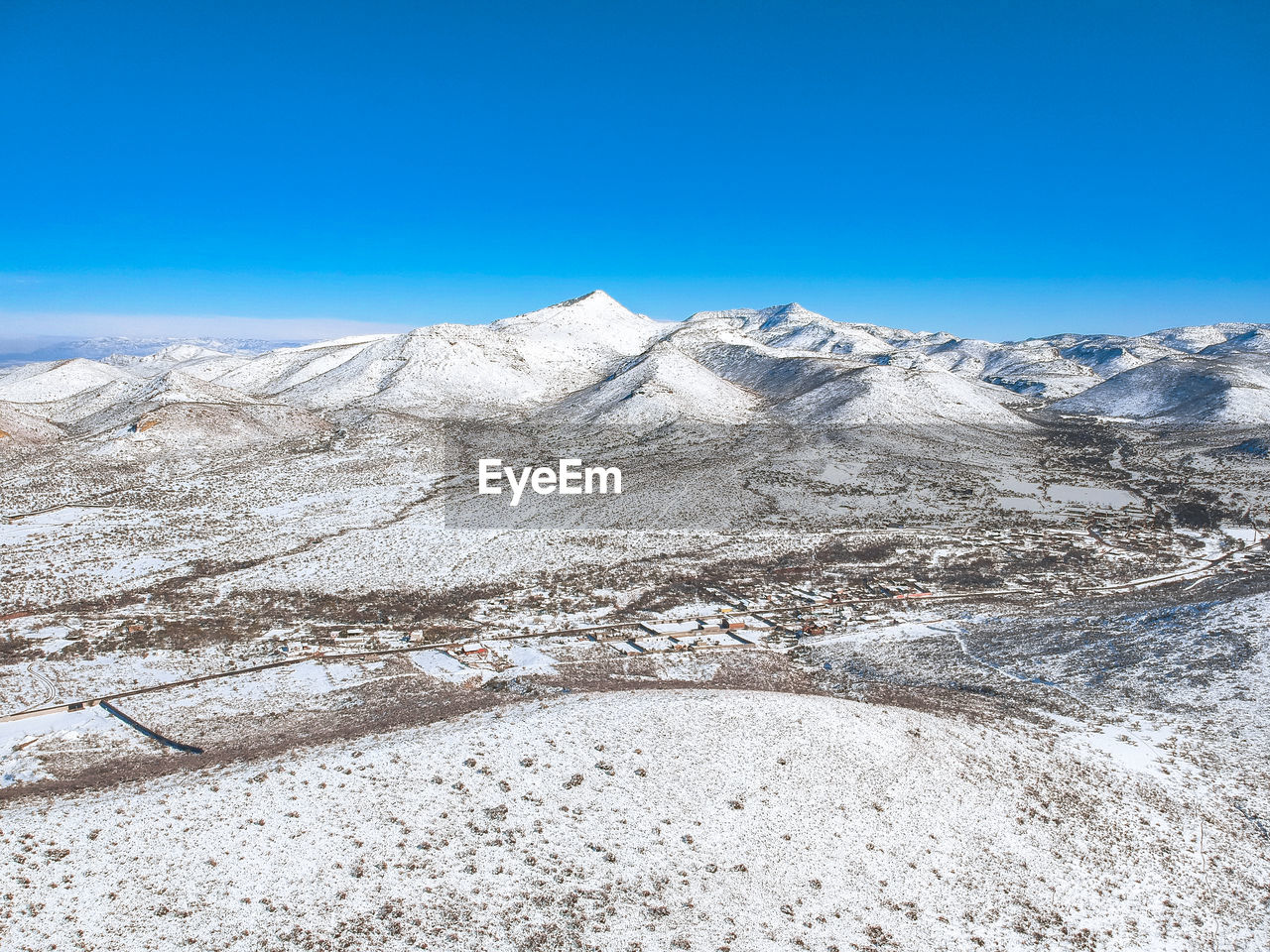 Scenic view of snowcapped mountain against blue sky