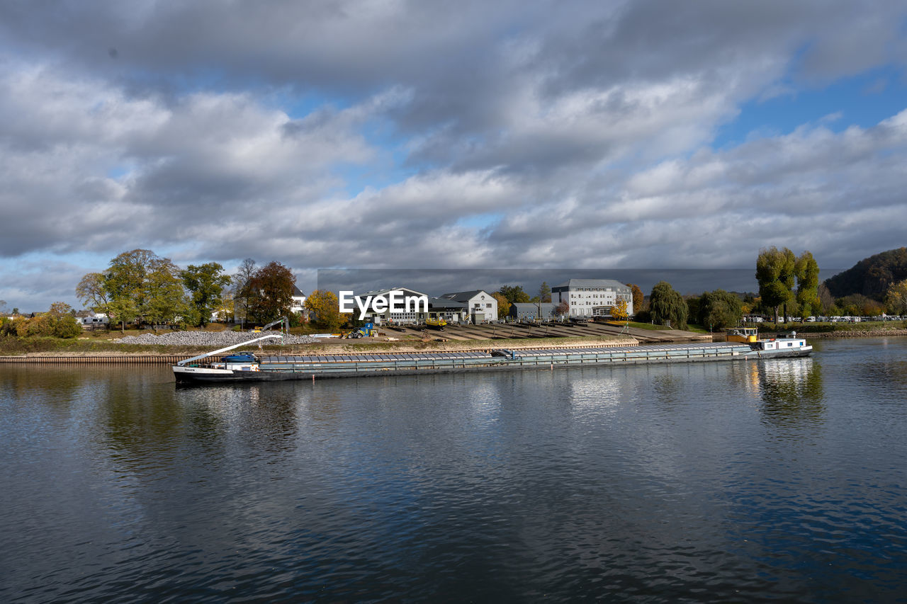 scenic view of lake by buildings against sky