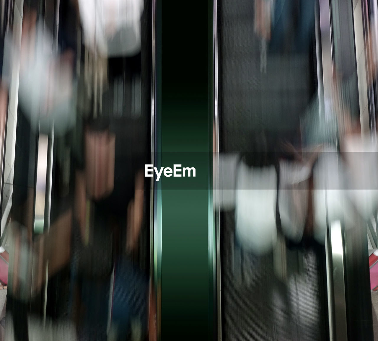 Blurred motion of people on escalator