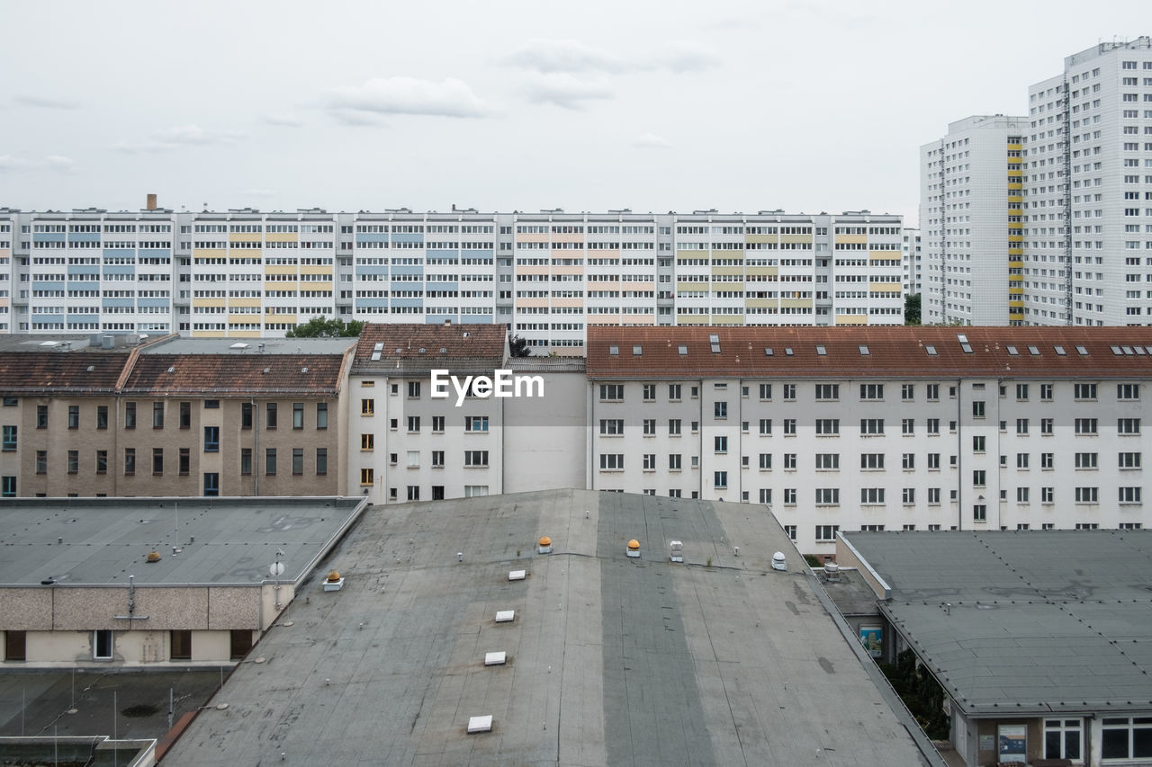 HIGH ANGLE VIEW OF ROAD BY BUILDINGS AGAINST SKY