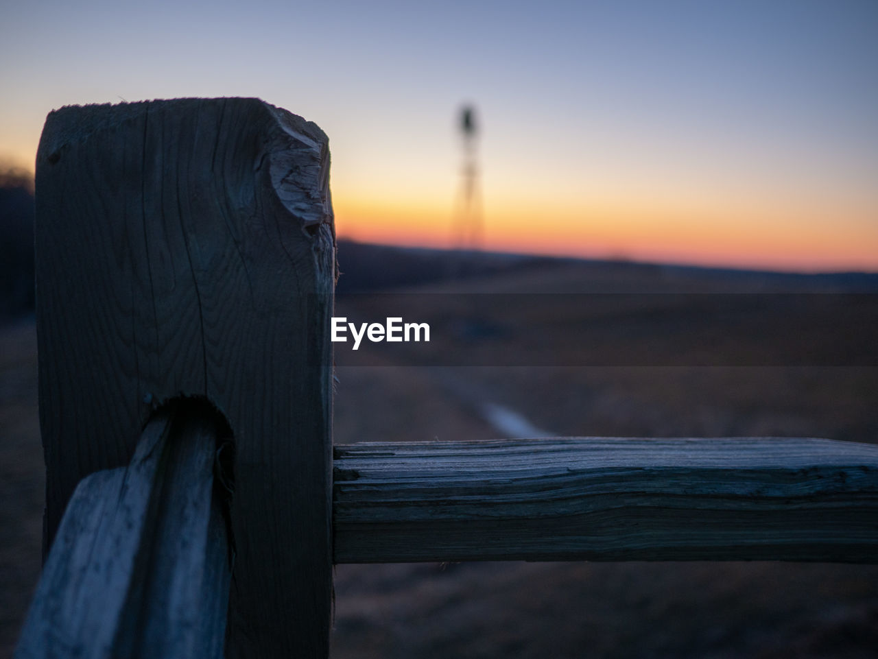 CLOSE-UP OF WOODEN FENCE ON LANDSCAPE AGAINST SKY