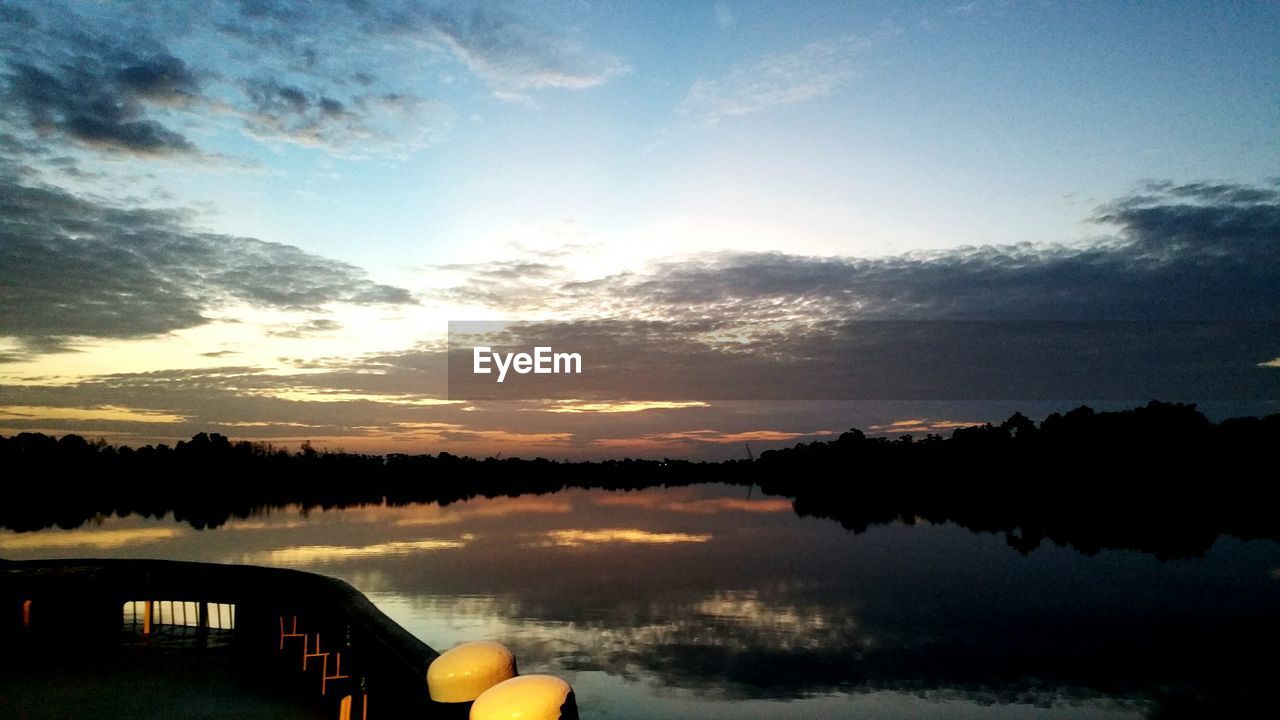 SCENIC VIEW OF CALM LAKE AT SUNSET