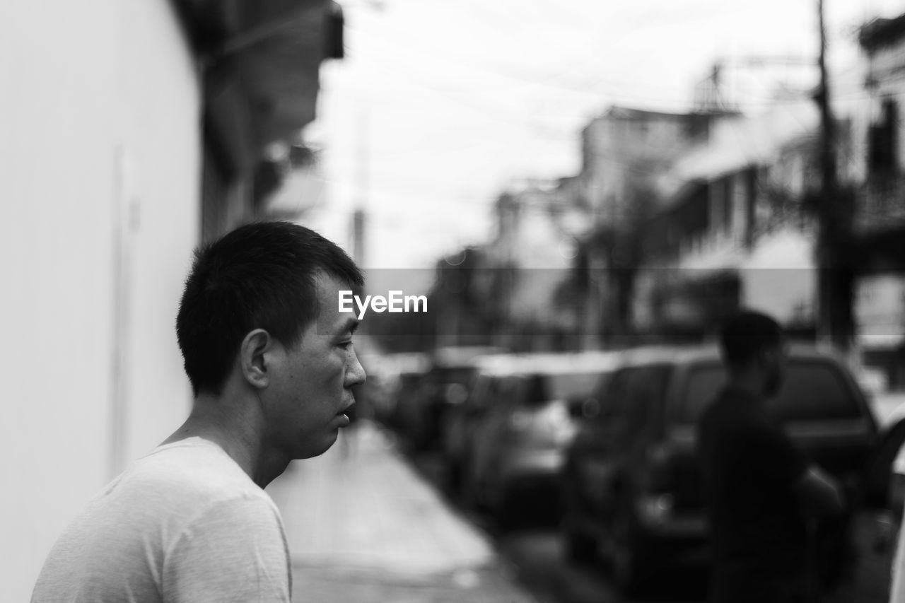 SIDE VIEW PORTRAIT OF A MAN IN CITY STREET