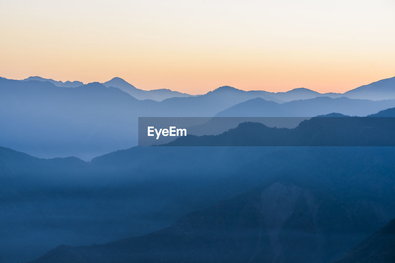 SCENIC VIEW OF MOUNTAINS AGAINST SKY AT SUNSET