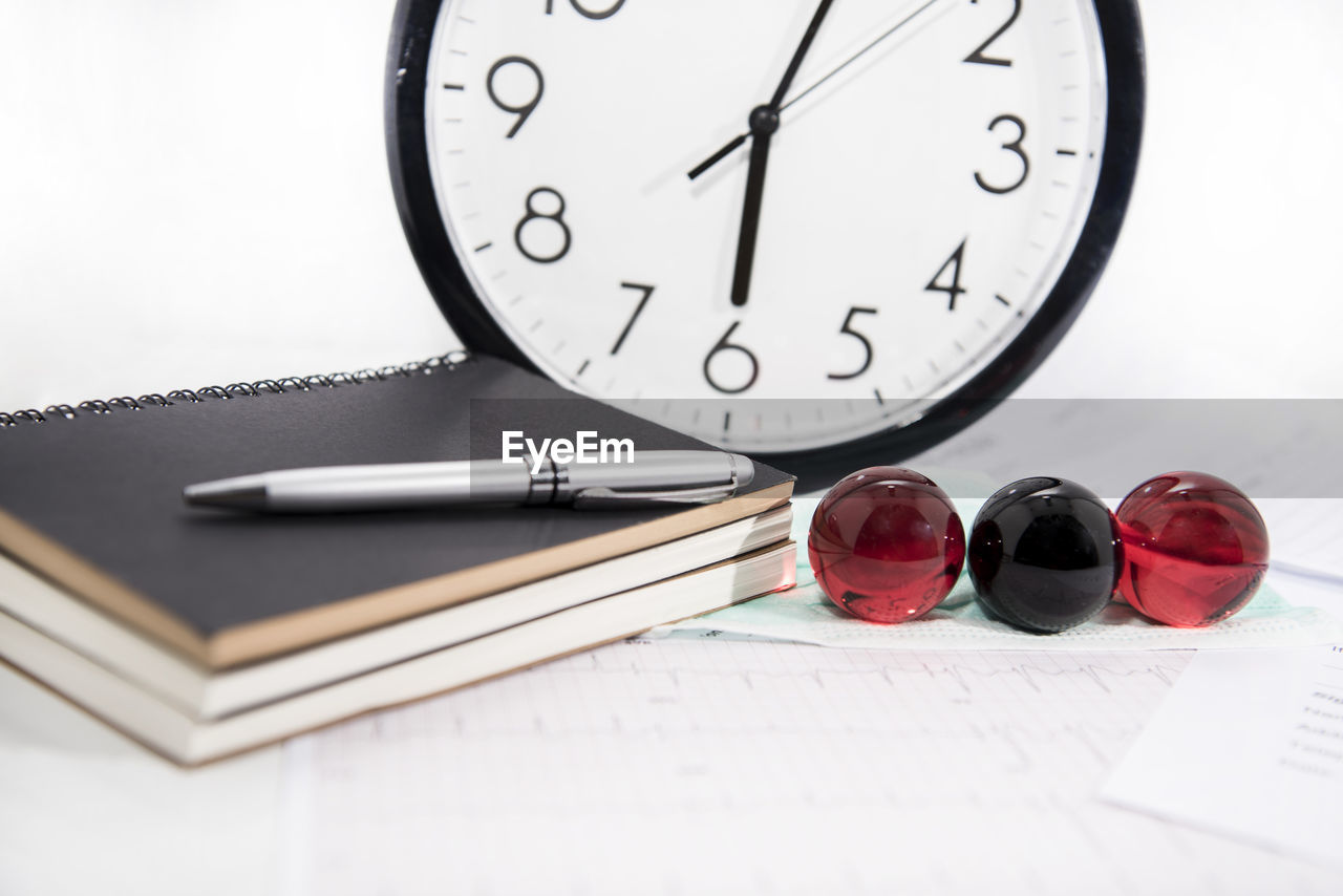 CLOSE-UP OF CLOCK ON OPEN BOOK