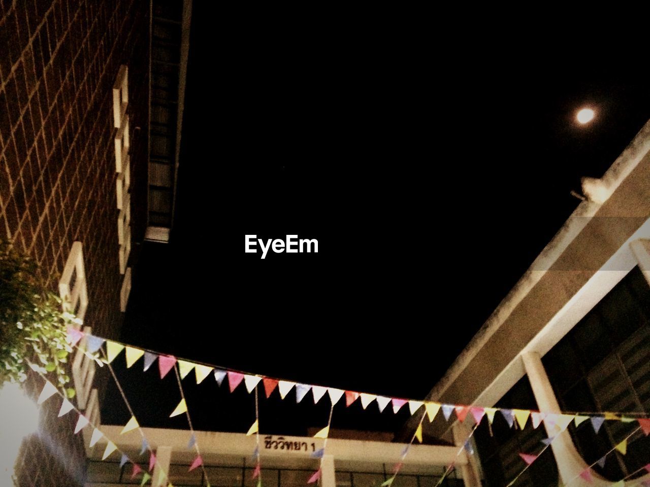 LOW ANGLE VIEW OF ILLUMINATED BUILDING AT NIGHT