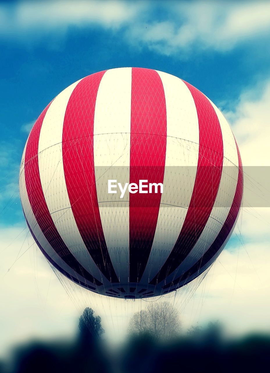 hot air balloon, aircraft, hot air ballooning, vehicle, air vehicle, balloon, transportation, sky, cloud, nature, mid-air, flying, red, adventure, toy, blue, outdoors, multi colored, no people, executive car, mode of transportation, day, ballooning festival, sports