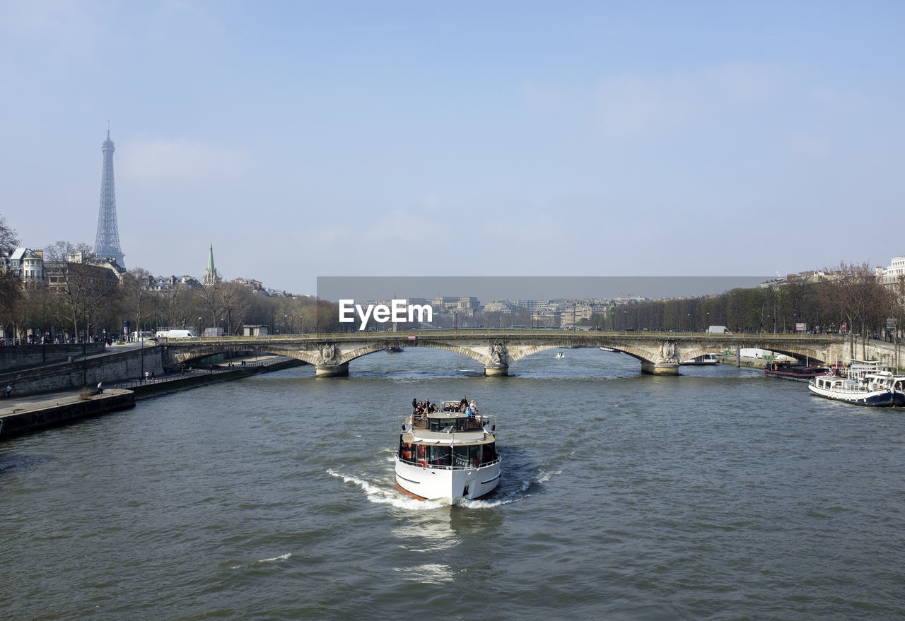 Boats in river with city in background