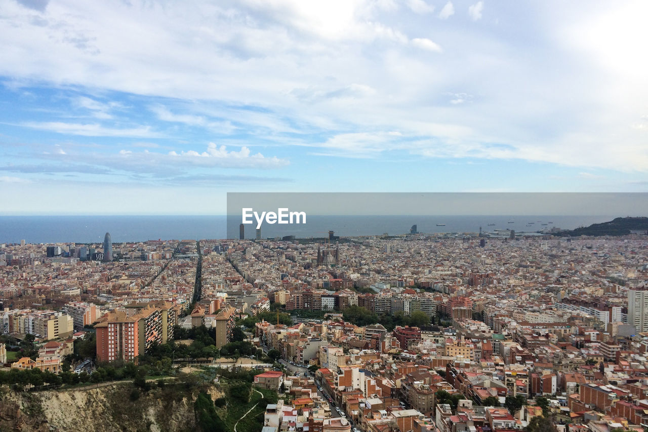 Aerial view of cityscape by sea against sky