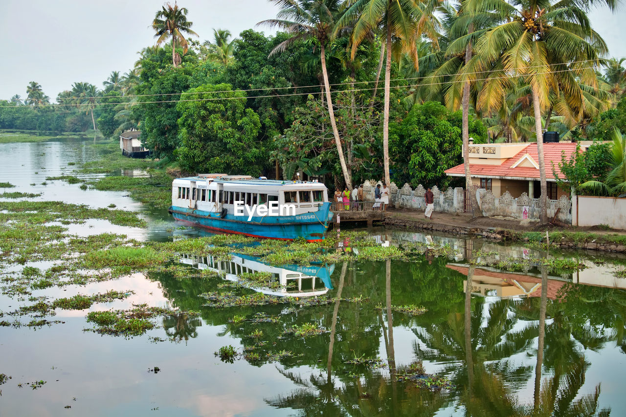 Boat in canal by trees