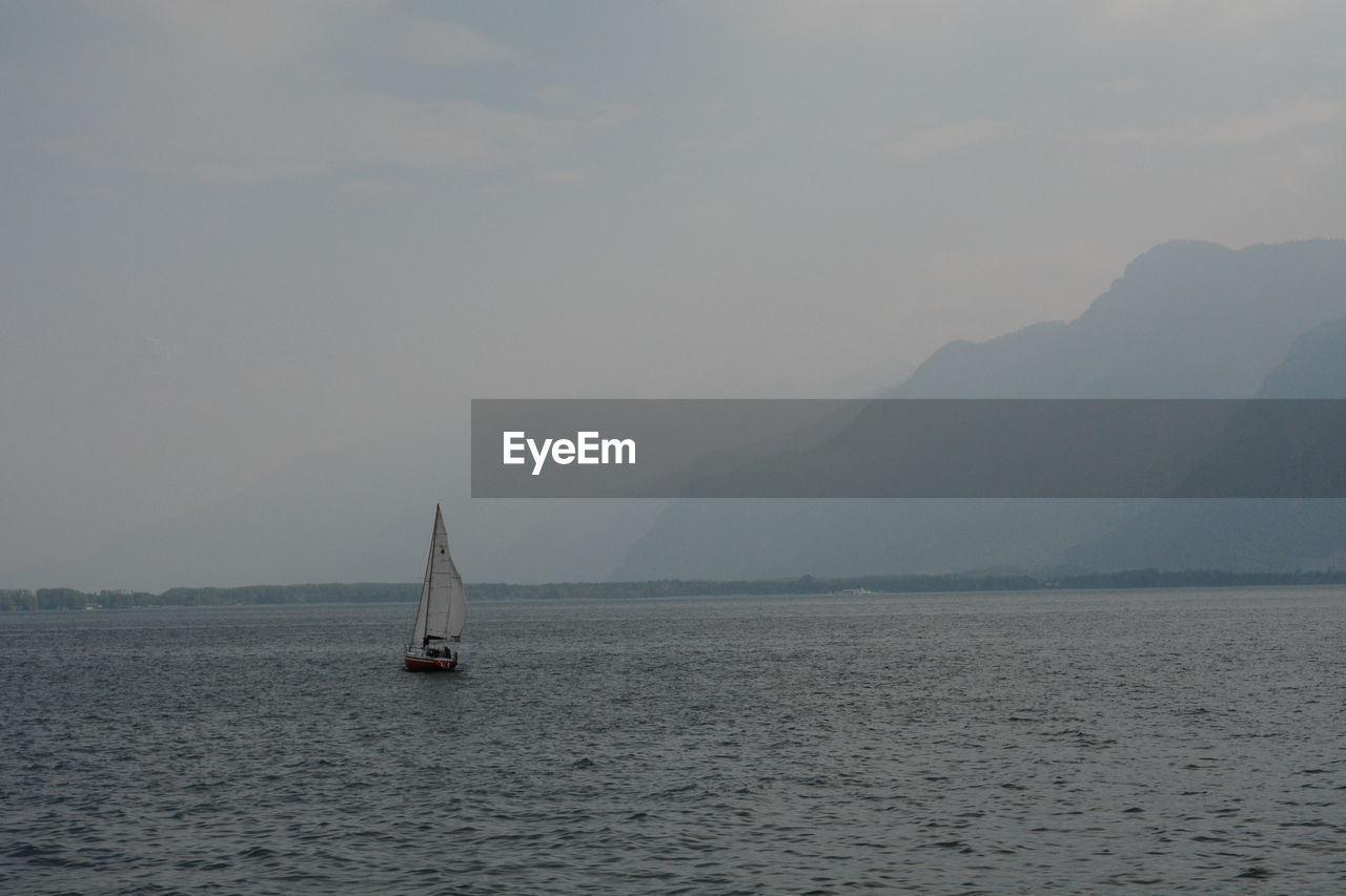 Sailboat sailing on sea against sky