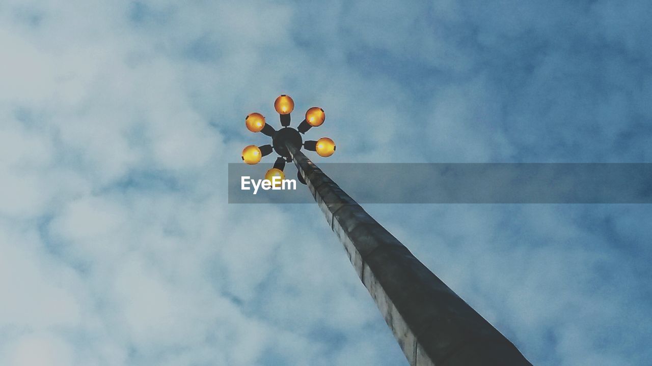 Low angle view of lamp post against clouds