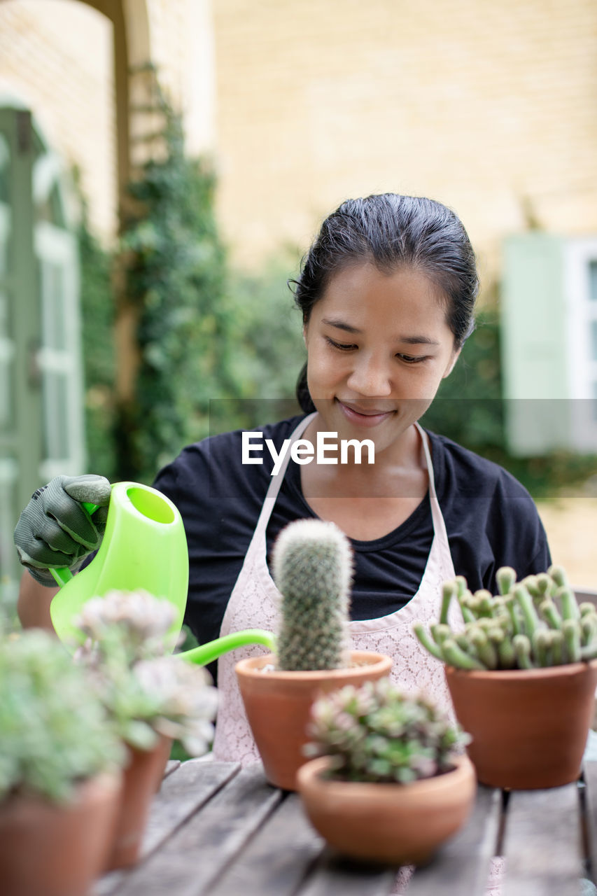 Woman watering succulent plant at workshop