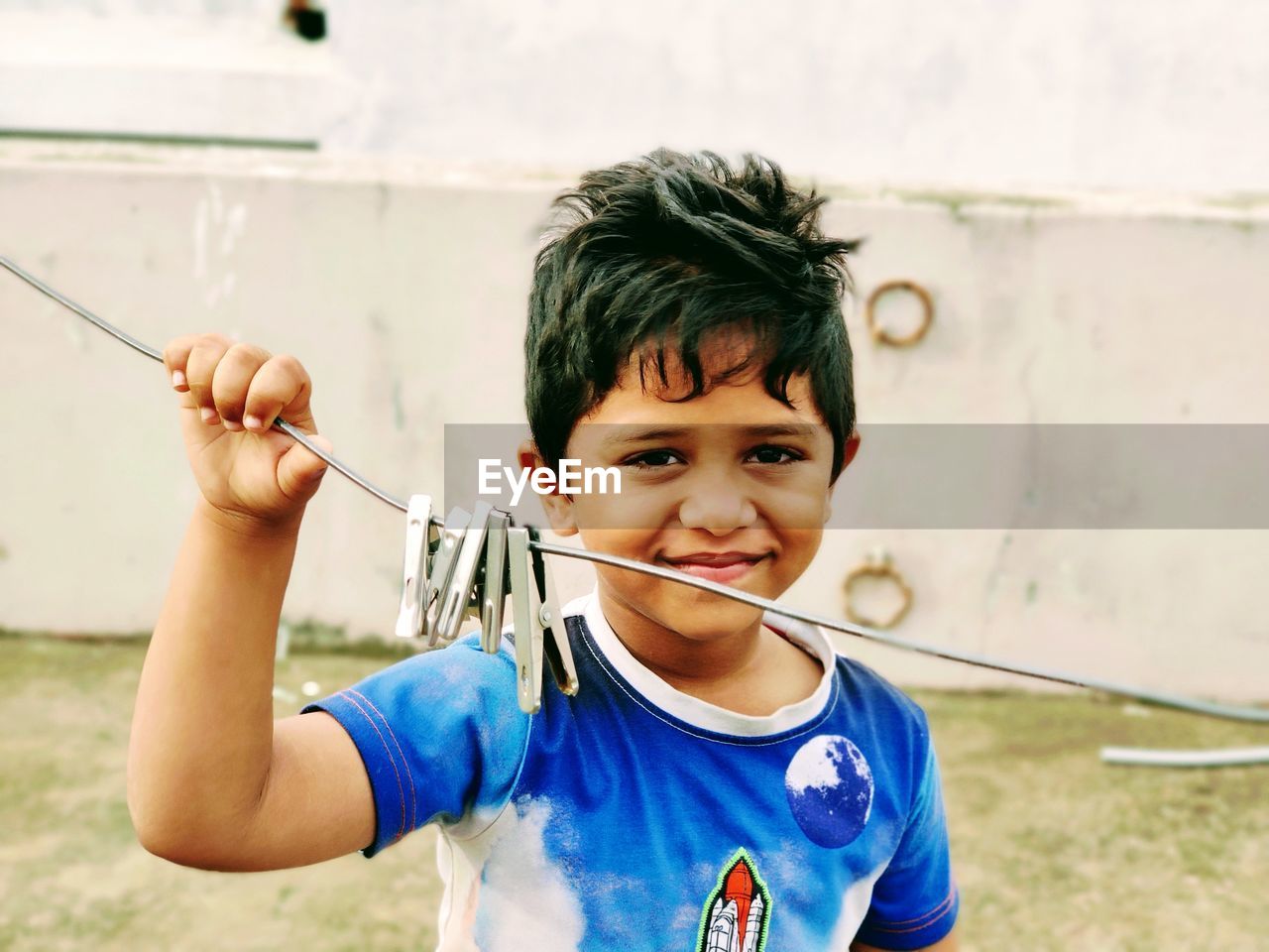 Portrait of boy holding clothesline