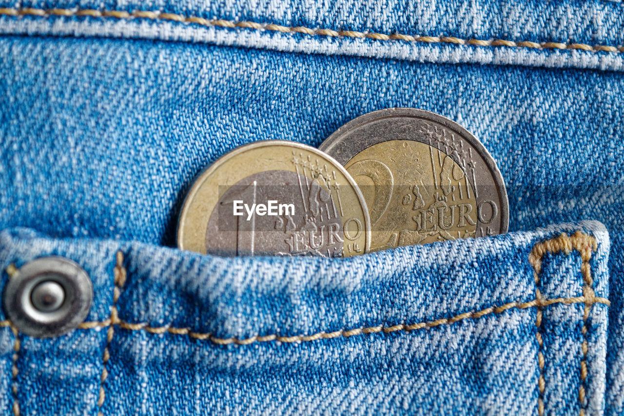 Close-up of coins in jeans pocket