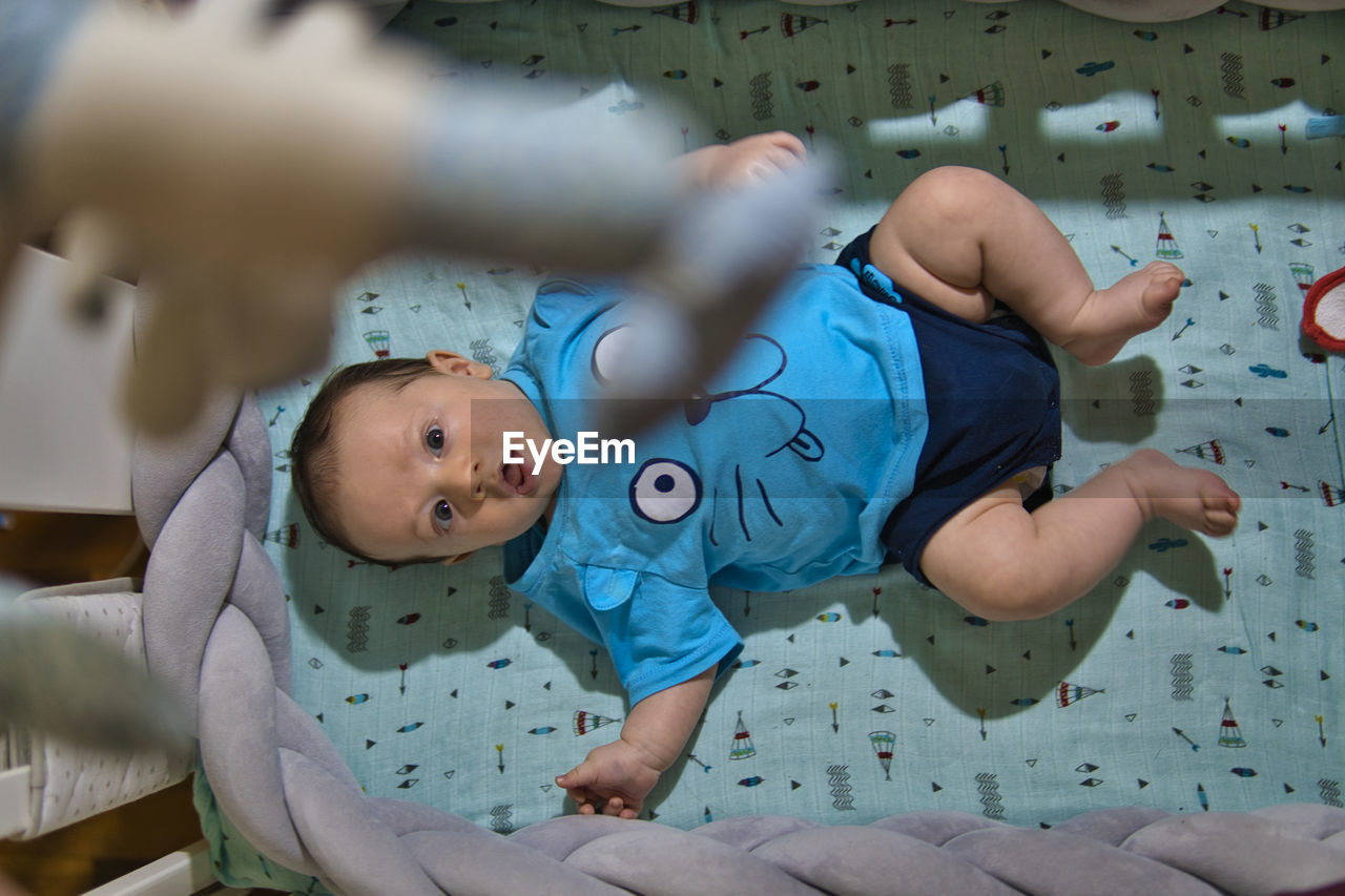 Full length of cute baby lying down on bed