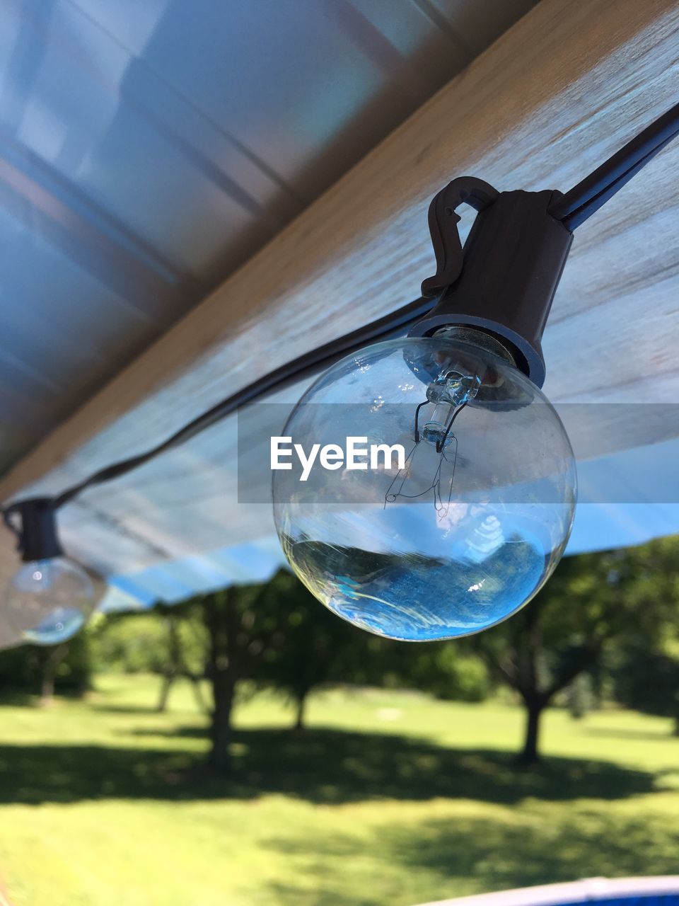 CLOSE-UP OF LIGHT BULB HANGING FROM GLASS