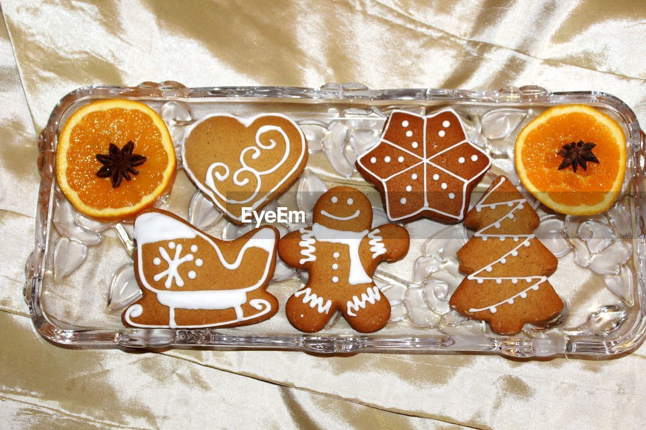 High angle view of gingerbread cookies in tray on textile