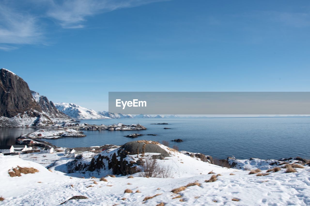 Scenic view of sea and snowcapped mountains against sky