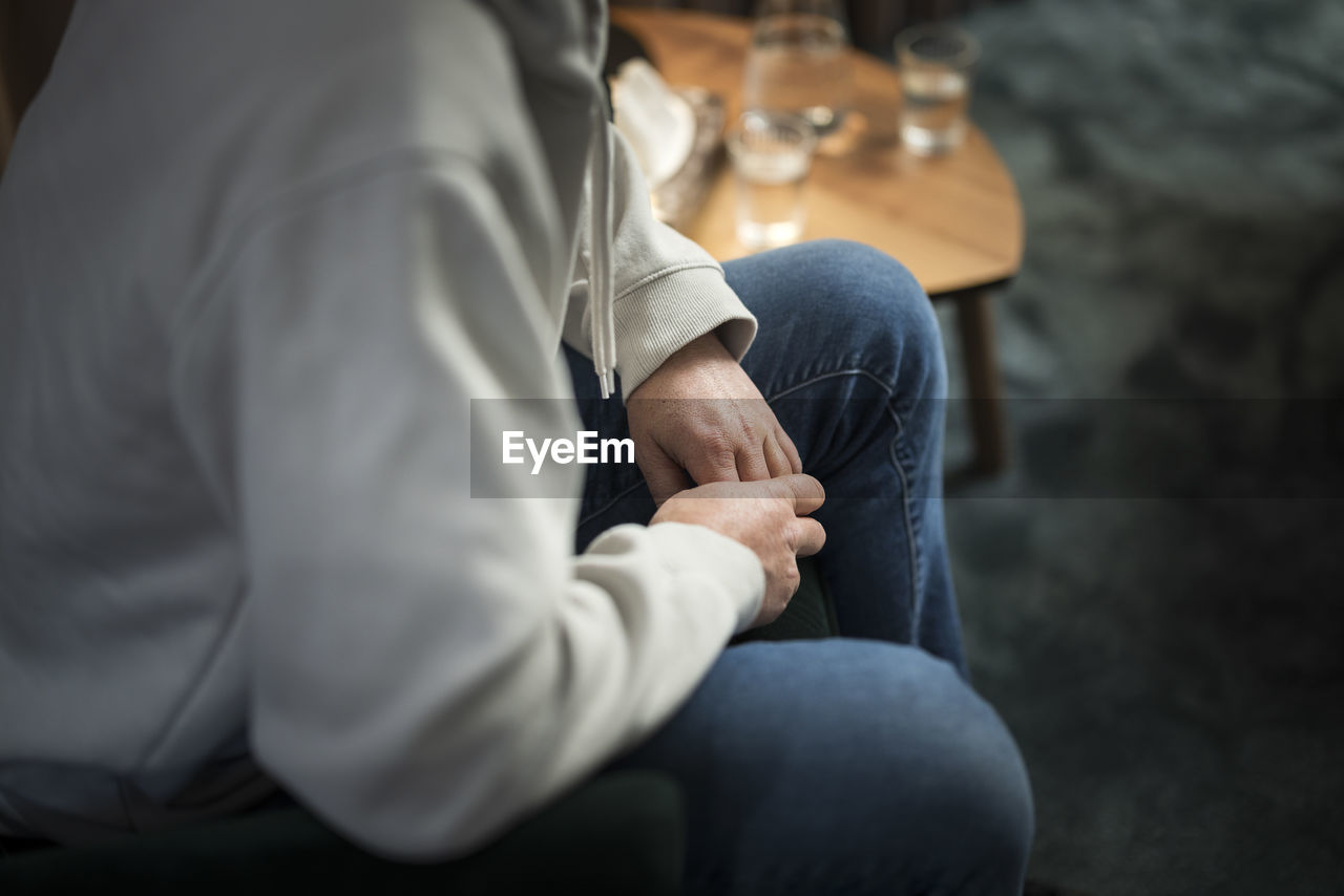 Man wringing hands at therapy session