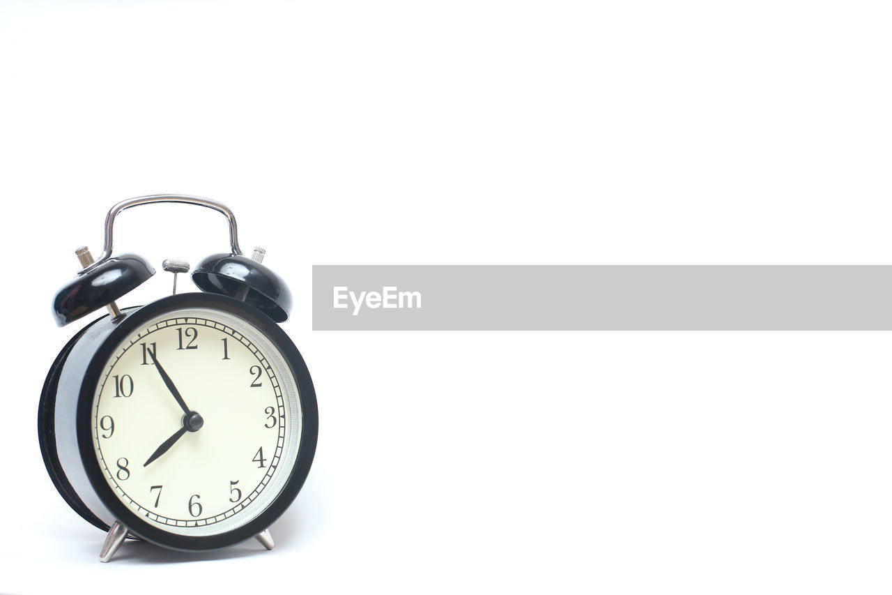 Close-up of alarm clock on white background