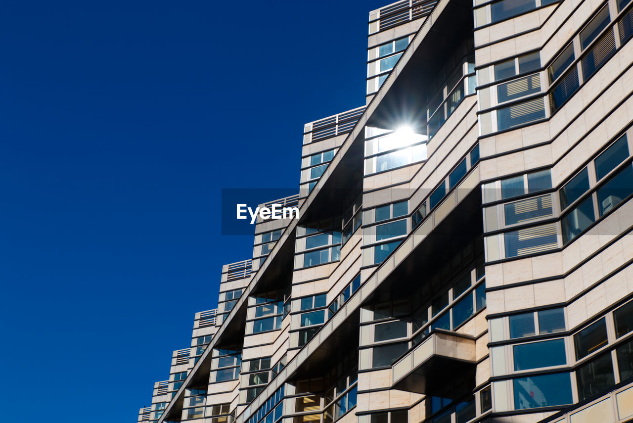 Low angle view of modern building against clear blue sky