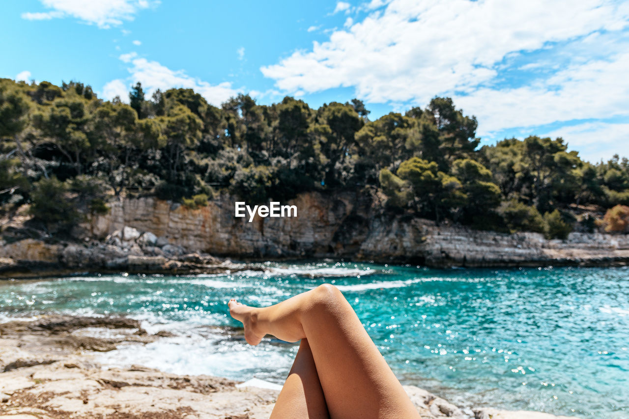 Legs of young woman, personal perspective, sea, summer, vacation.