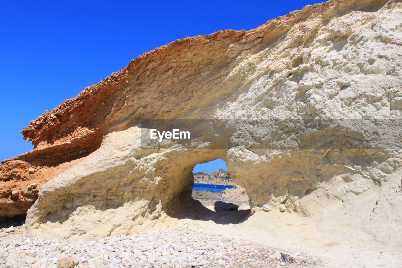 Rock formations against clear blue sky